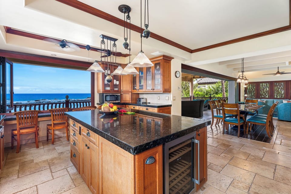 Expansive kitchen island with wine fridge and pendant lighting—ideal for prepping meals or gathering casually.