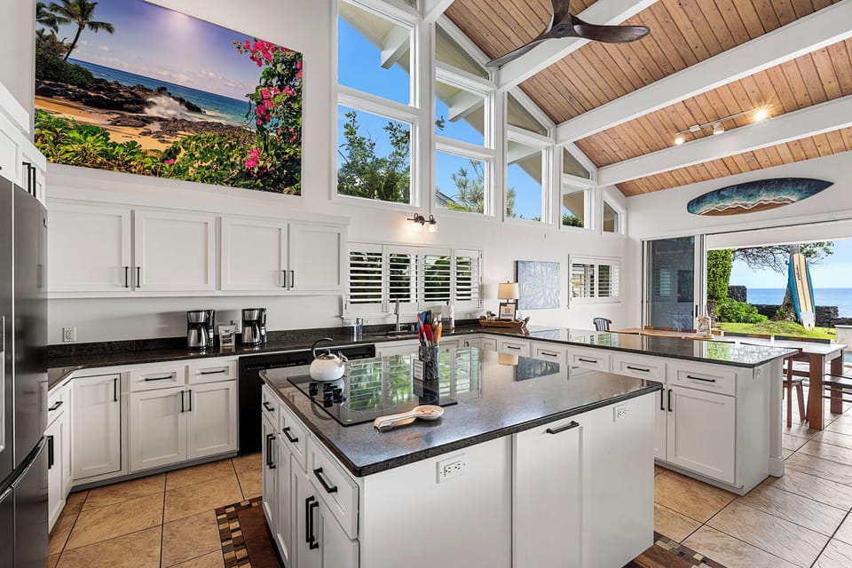 Prepare meals in a light-filled kitchen, with vaulted ceilings and ocean views beyond.