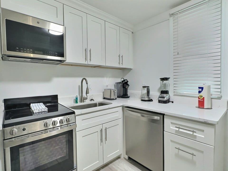 Kitchen view showing stainless range, built-in microwave, dishwasher, and sink