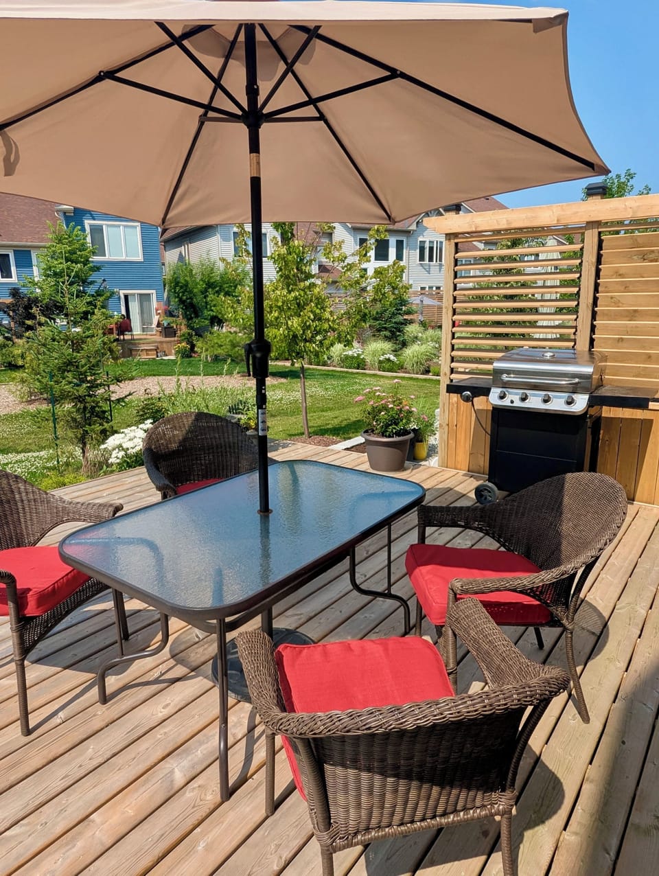 Wooden deck fully equipped with comfortable furniture, sun umbrella, and BBQ!
