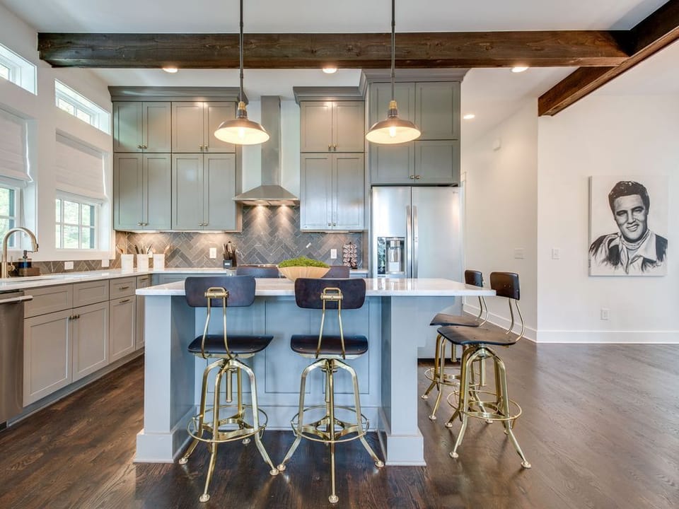 - Step into this inviting kitchen designed with warm lighting and tall cabinets   - Large island with seating makes gathering effortless   - Stainless appliances and clean lines enhance the space