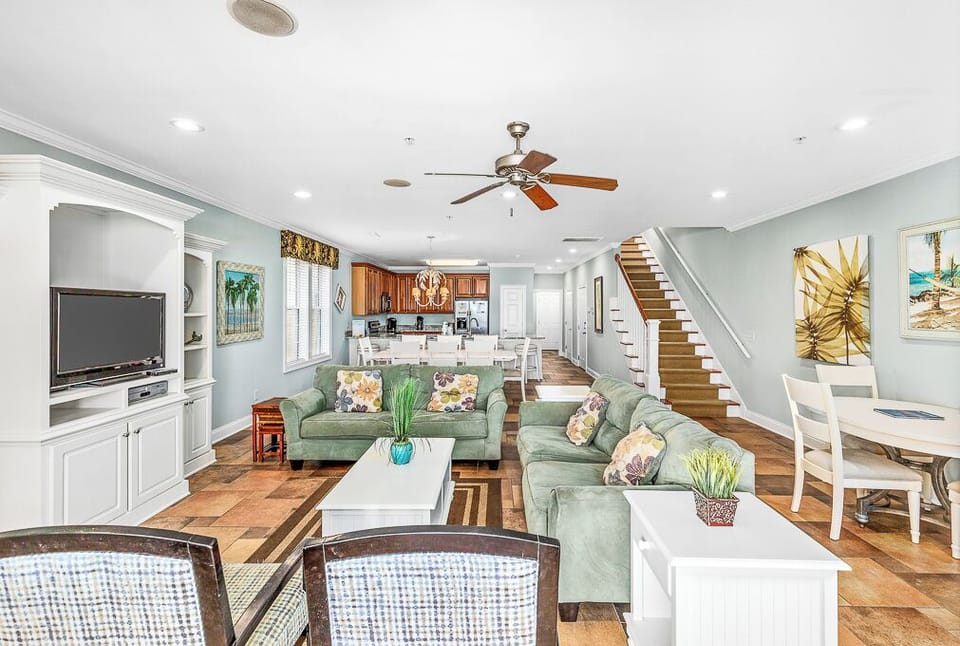 Relax in your spacious open-concept living space with comfortable seating, modern kitchen, and coastal-inspired décor that creates the perfect beach getaway atmosphere.