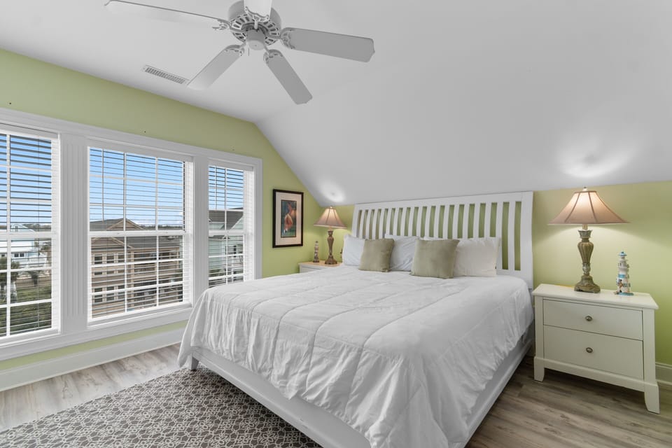 Drift off to sleep in your bright, airy bedroom with crisp white linens and gentle ceiling fan keeping you cool.