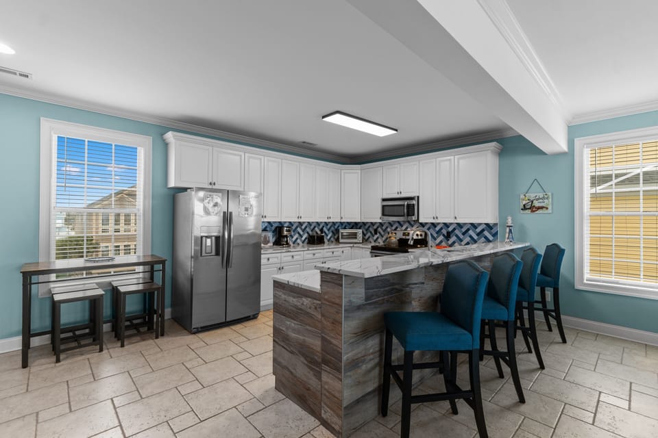 Your fully equipped kitchen welcomes you with coastal-inspired blue hues, perfect for creating memorable meals together.
