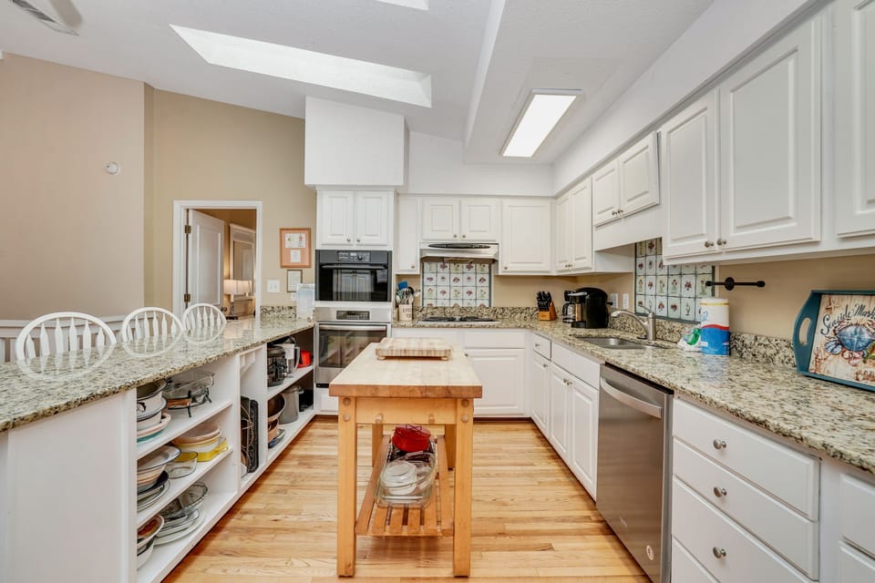 Your fully equipped kitchen awaits with granite countertops, custom cabinetry, and a charming butcher block island for preparing meals together.