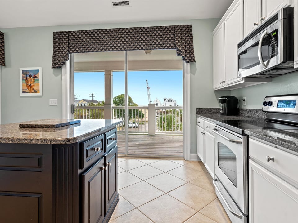 Your fully equipped kitchen opens to a private balcony with views, perfect for morning coffee or preparing meals with fresh sea air.