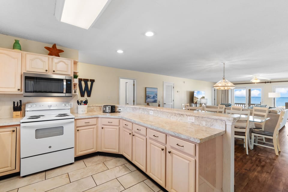 Your fully equipped kitchen flows seamlessly into the dining area, where ocean views create the perfect backdrop for memorable meals.