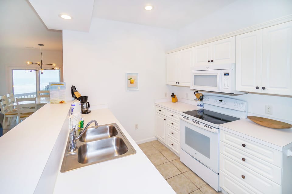Your fully equipped kitchen features modern appliances and bright white cabinetry, perfect for preparing meals during your stay.