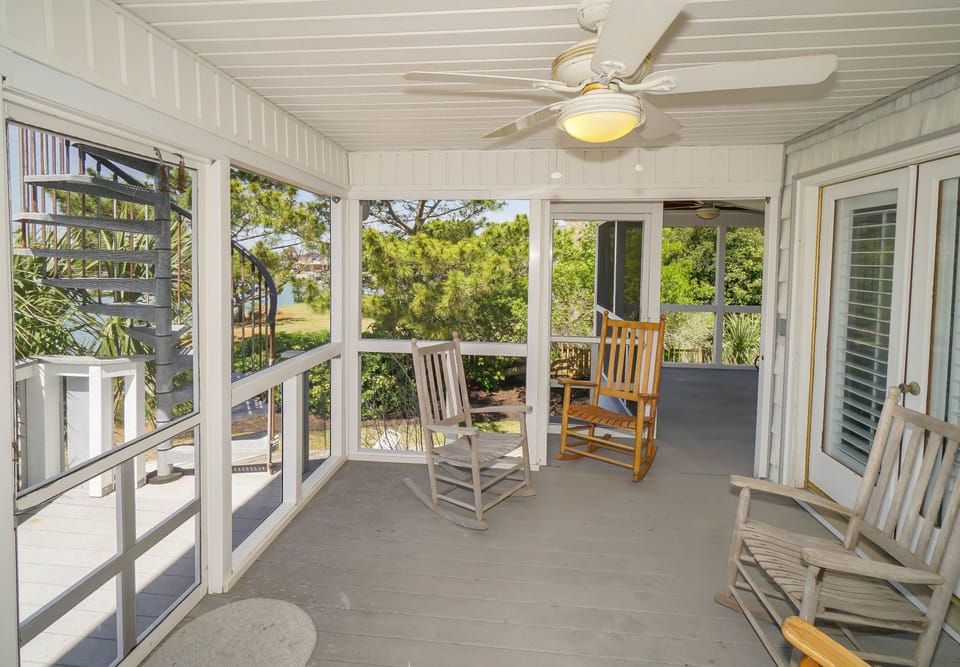 Unwind on your screened porch with rocking chairs and peaceful garden views, where gentle breezes and natural light create the perfect retreat.