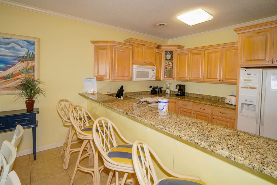 Cook up delicious meals in your spacious kitchen featuring granite counters, modern appliances, and a breakfast bar perfect for casual dining.