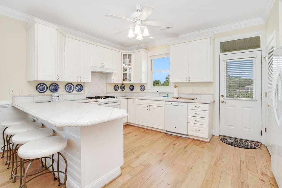 Your bright kitchen features white cabinets, granite counters, and breakfast bar seating where you can enjoy morning coffee with natural light.