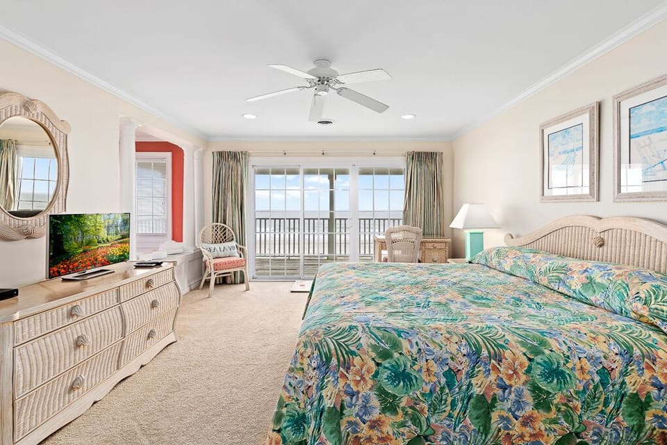 Relax in this tropical paradise bedroom with vibrant bedding, wicker furnishings, and your private balcony overlooking endless views.