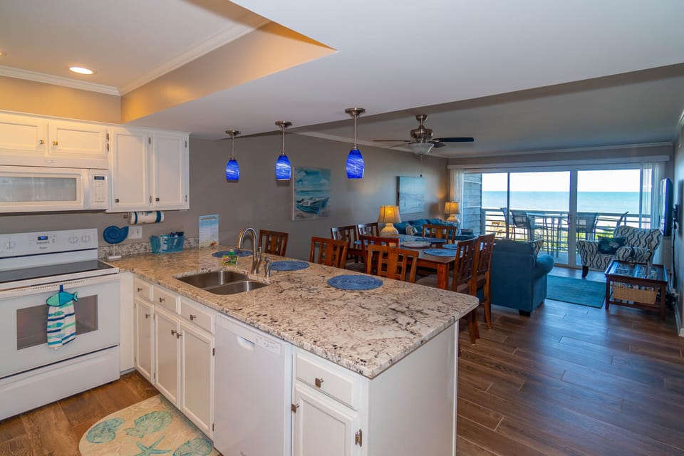 Your bright open kitchen flows seamlessly into the dining and living areas, with stunning ocean views creating the perfect backdrop for cooking and gathering.