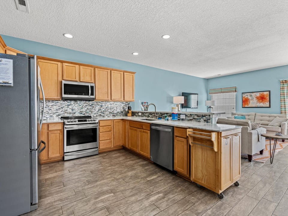 Your fully equipped kitchen features granite counters, stainless appliances, and a breakfast bar perfect for casual dining.