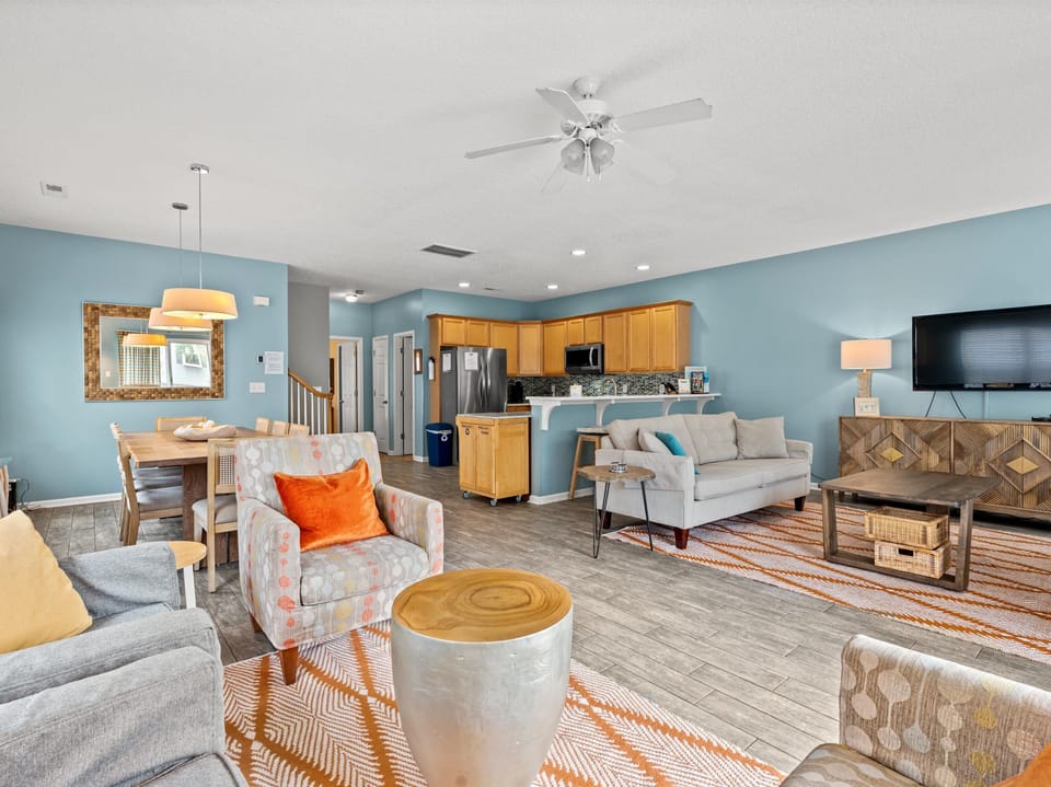 Unwind in your spacious open-concept living area where calming blue walls, plush seating, and modern amenities create the perfect retreat for relaxation.