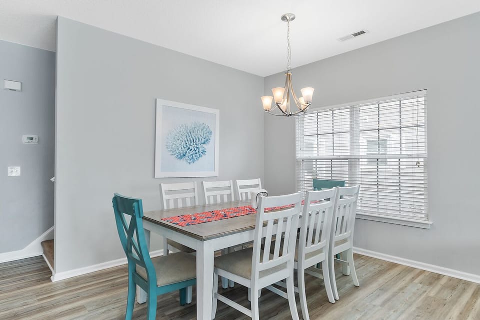 Gather around this elegant dining table where memorable meals and conversations unfold under warm chandelier lighting in your serene dining space.