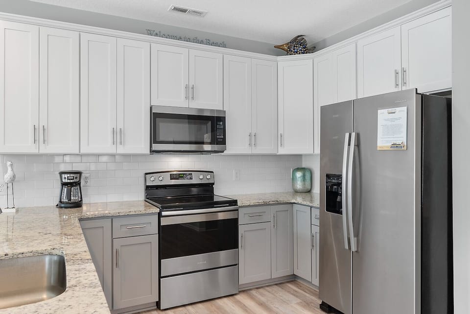 Your fully equipped kitchen features stainless steel appliances, granite countertops, and crisp white cabinetry for all your culinary adventures.