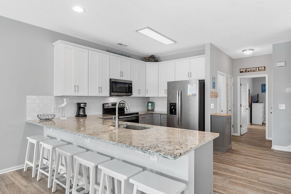 Your spacious kitchen features granite countertops, stainless steel appliances, and a breakfast bar perfect for morning coffee or casual meals.