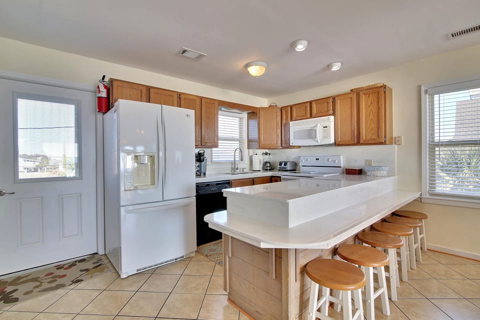 Your spacious kitchen features modern appliances, breakfast bar seating, and everything needed for memorable home-cooked meals during your stay.