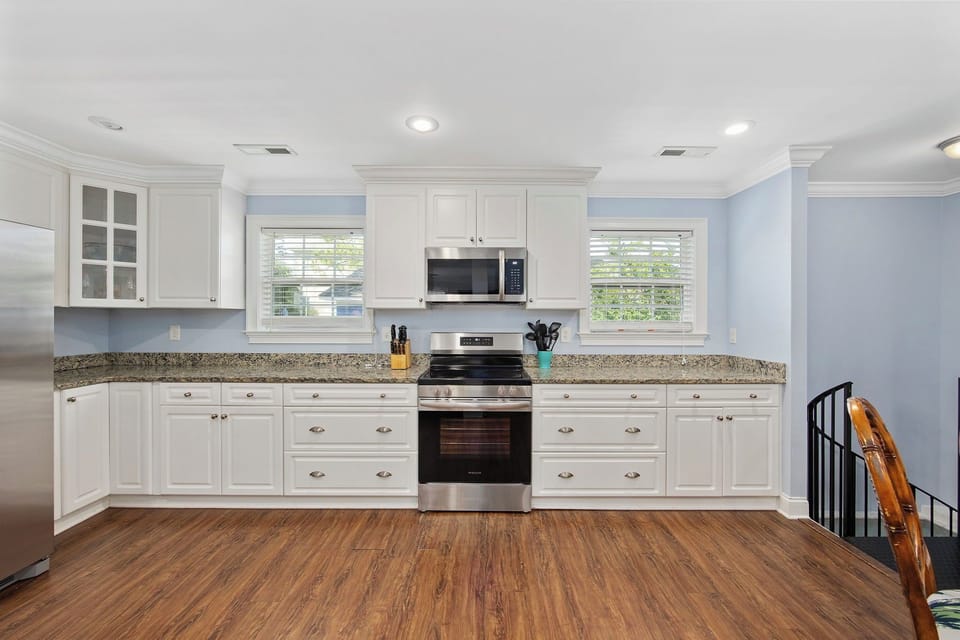 Cook memorable meals in your fully-equipped kitchen featuring granite countertops, stainless appliances, and bright natural light from dual windows.