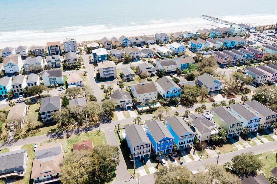 Charming beachfront community featuring colorful coastal homes just steps from pristine sandy shores and crystal-clear waters.
