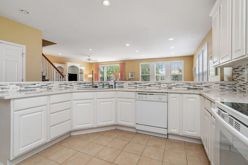 Your spacious kitchen awaits with gleaming white cabinets, granite counters, and modern appliances for memorable meal prep.