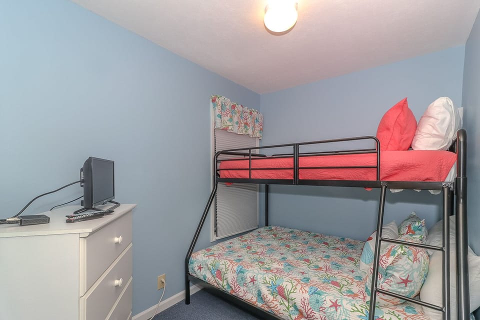 Your kids will love this cheerful bunk bed room with ocean-themed bedding and entertainment center for cozy family nights.