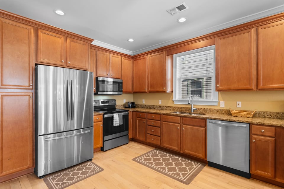 Your fully equipped kitchen features warm wood cabinets, granite countertops, and modern stainless steel appliances for all your culinary needs.