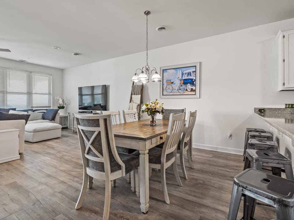 Gather around your elegant dining table where fresh flowers welcome shared meals and laughter in this bright, open living space.