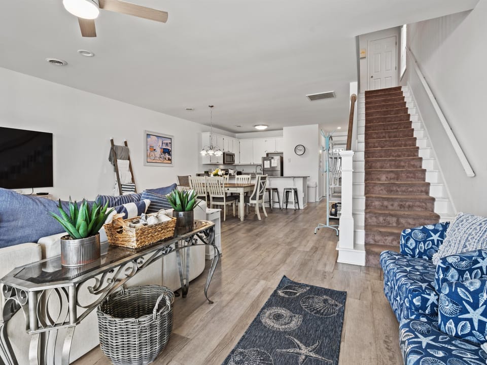 Unwind in your spacious open-concept living area where coastal blues meet modern comfort, complete with full kitchen and cozy seating for relaxing evenings.
