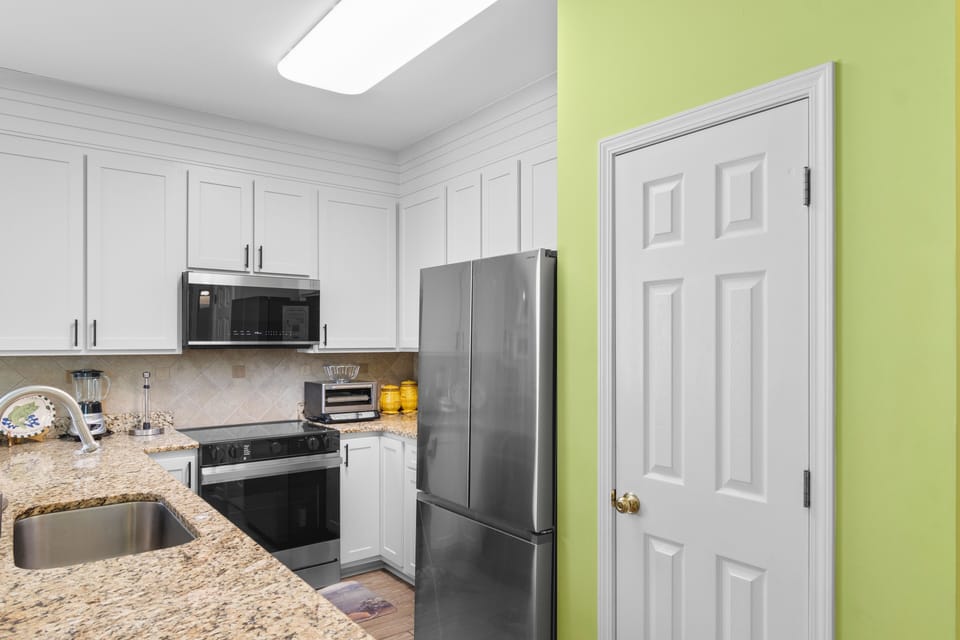 Your fully-equipped kitchen features granite countertops, stainless steel appliances, and bright white cabinetry for all your culinary adventures.
