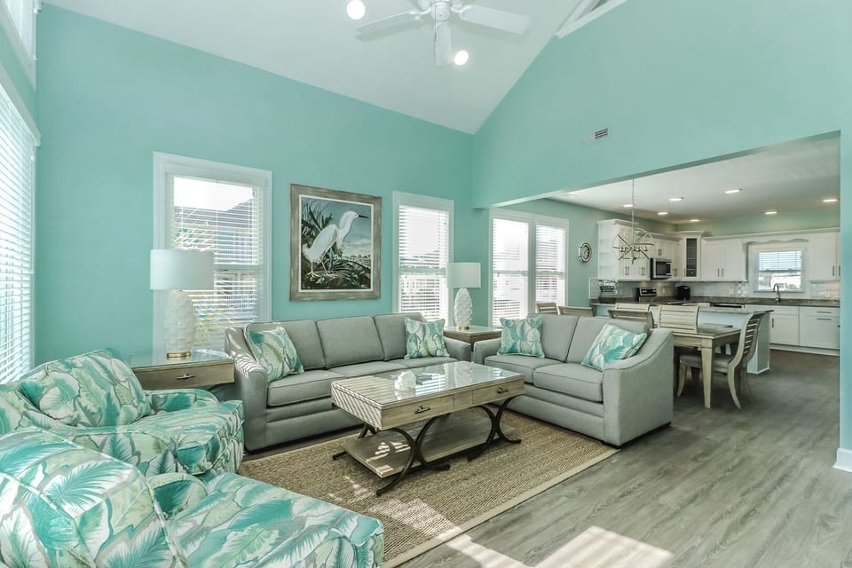 Sink into your coastal sanctuary where bright walls and tropical accents create the perfect beach retreat atmosphere for relaxation.