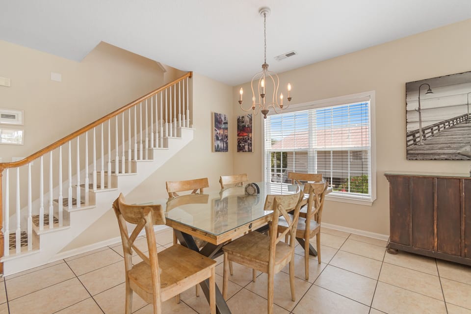 Gather around this elegant glass dining table where memorable meals and conversations unfold beneath warm chandelier light.