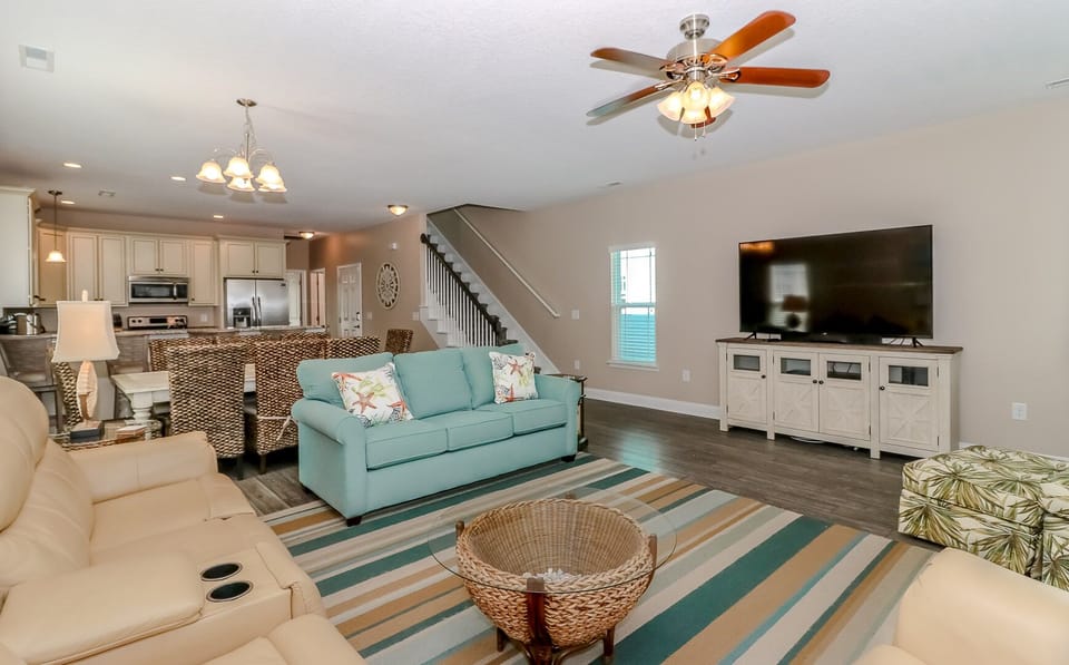 Relax in your spacious open-plan living area with plush seating, modern kitchen, and entertainment center—perfect for unwinding after beach adventures.
