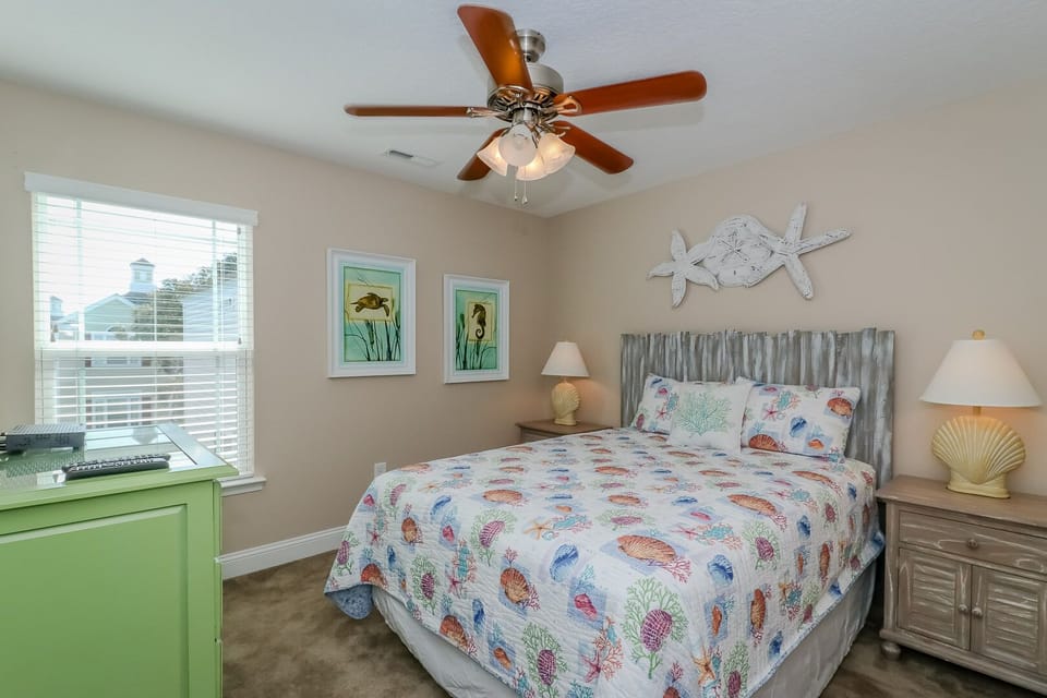 Drift off to coastal dreams in your bright bedroom, complete with nautical decor and a gentle ceiling fan for comfort.