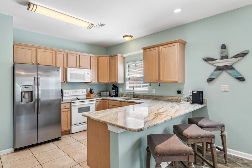 Your fully equipped kitchen awaits with granite counters, stainless appliances, and breakfast bar seating for easy meal prep.