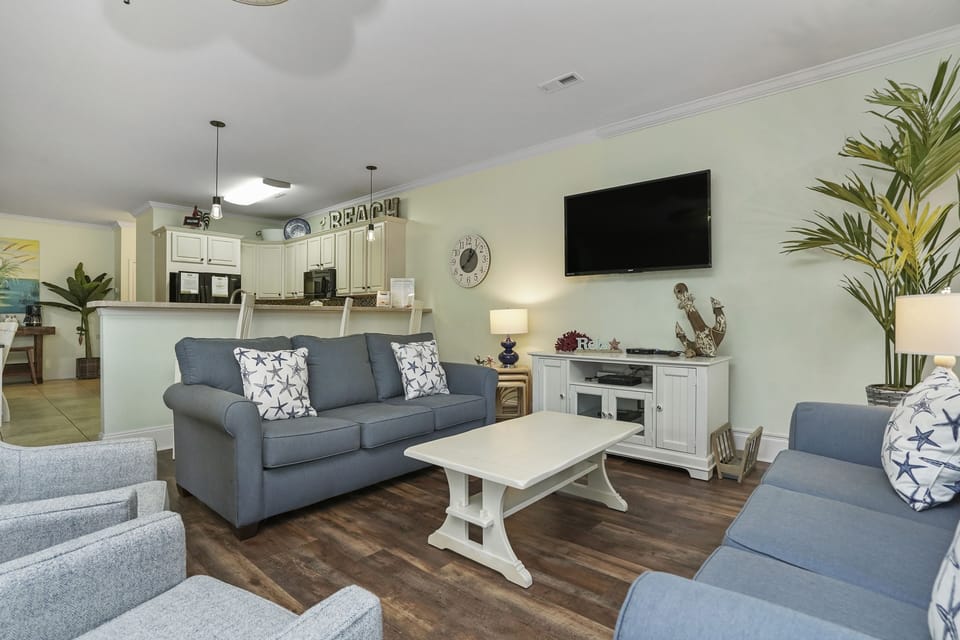 Sink into plush coastal-blue seating while your favorite shows play on the wall-mounted TV. The open-concept design flows into your fully equipped kitchen.