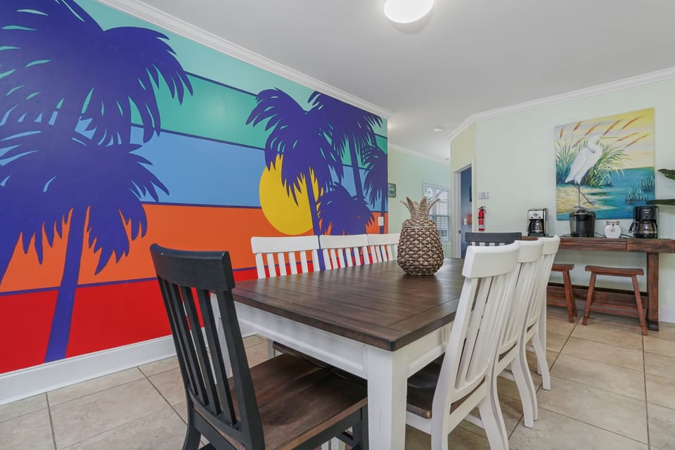 Gather around your tropical dining table beneath vibrant sunset murals that bring island paradise indoors.