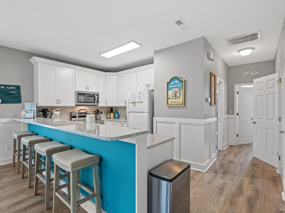 Your bright kitchen features white cabinets, granite counters, and a cheerful turquoise breakfast bar where you can start each morning with coffee.