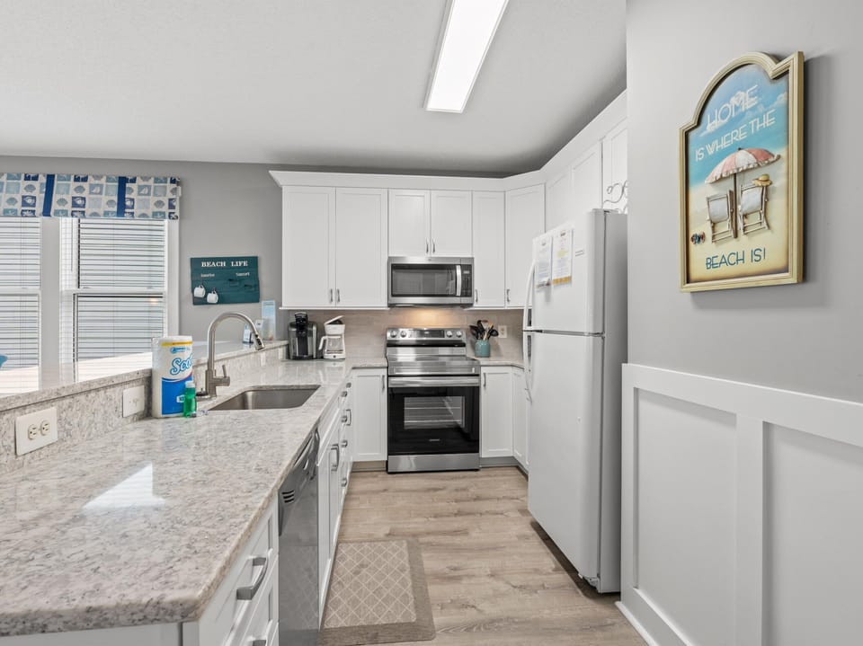 Your fully equipped kitchen features granite counters, stainless appliances, and beach-themed charm for cooking memorable vacation meals.