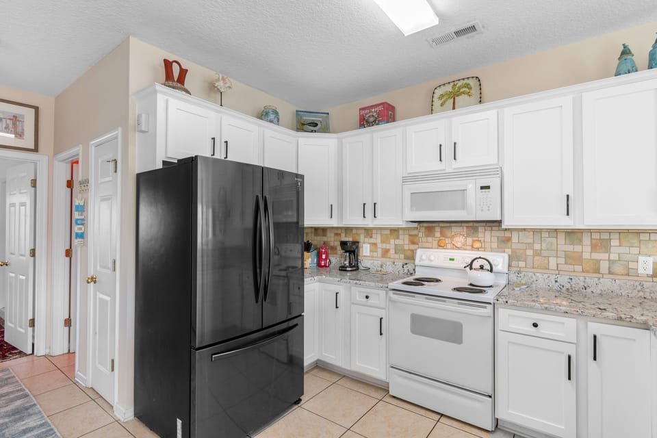 Cook your favorite meals in this fully equipped kitchen with granite counters, modern appliances, and ample storage space.