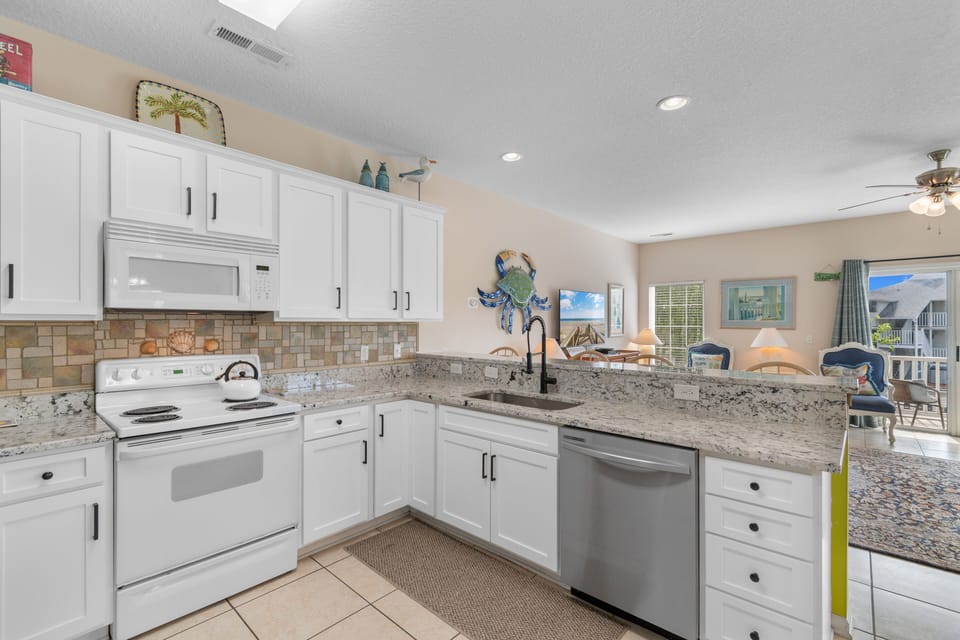 Your spacious kitchen features granite countertops, stainless steel appliances, and coastal charm—perfect for preparing memorable meals together.