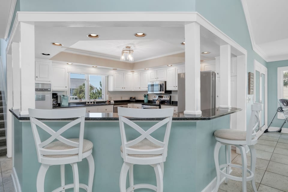 Your dream kitchen awaits with elegant white cabinetry and soothing coastal colors, perfect for preparing memorable vacation meals.