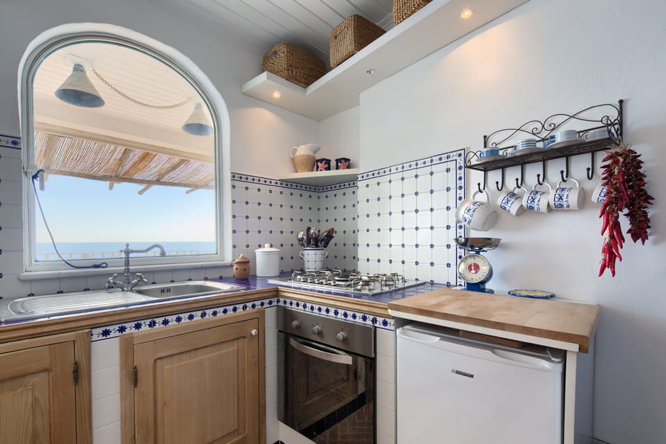 Kitchen with the view on the balcony and the sea