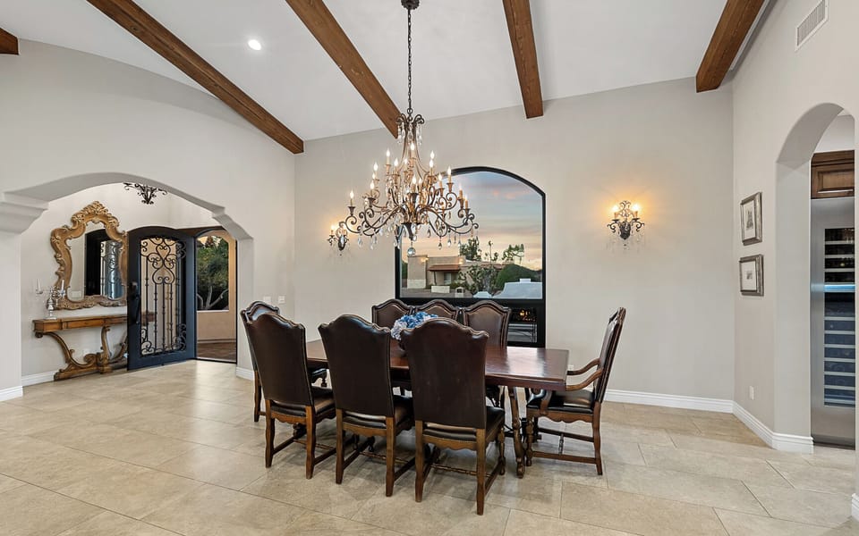 Dining table for 8 with chandelier, arched windows, and elegant decor
