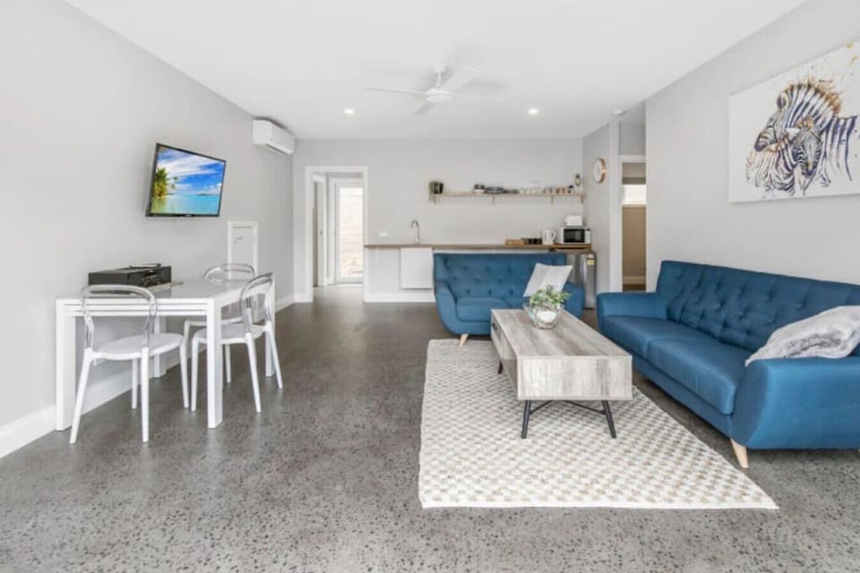 Separate downstairs living area with couches, TV, air conditioning/heating and a second kitchenette which includes a sink, fridge, kettle, toaster and microwave.