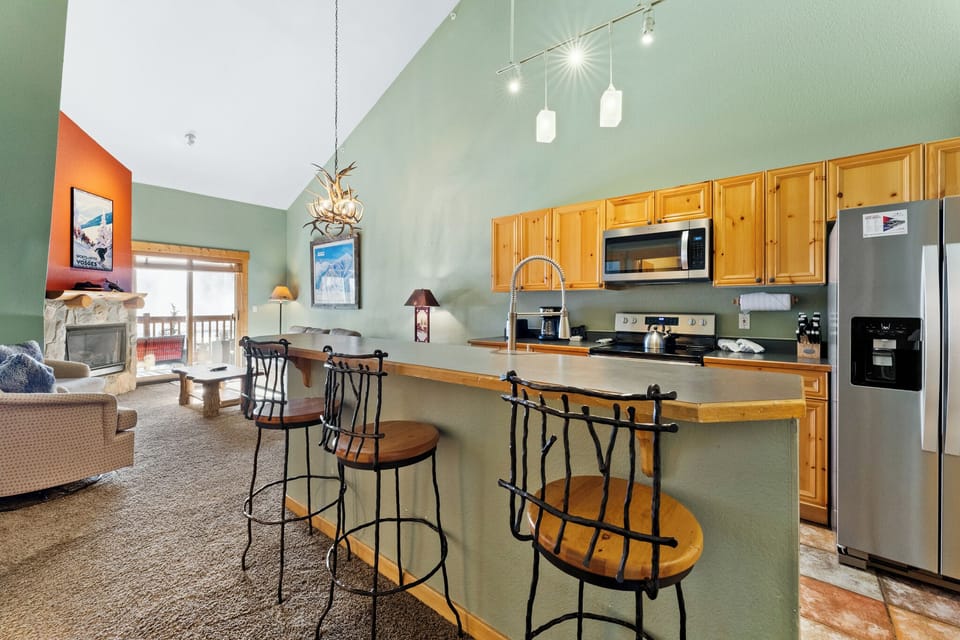 Your spacious open-plan retreat features a fully equipped kitchen with breakfast bar seating, perfect for casual meals and mountain coffee mornings.