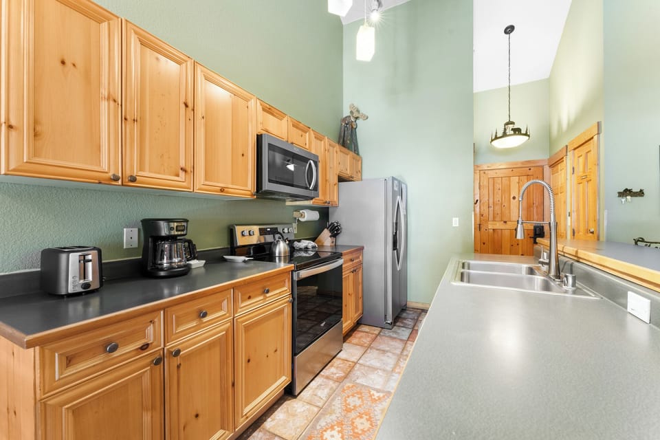 Your fully-equipped kitchen features warm wood cabinets and modern appliances for preparing delicious meals during your stay.
