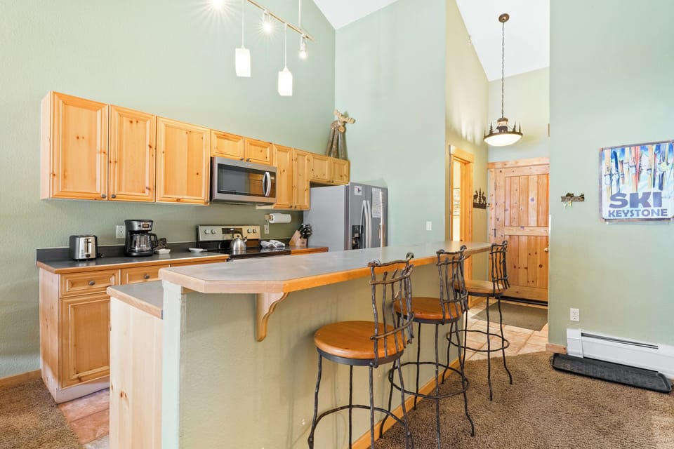 Your fully equipped kitchen features warm wood cabinets and a breakfast bar where you can enjoy morning coffee together.