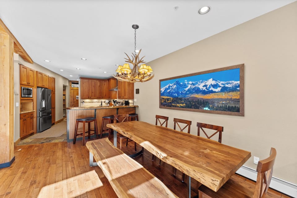 Gather around this stunning rustic dining table where your mountain memories are made, with a fully equipped kitchen ready for your culinary adventures.